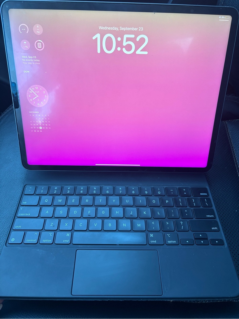 Apple iPad with Black Magic Keyboard and Pink Screen Background